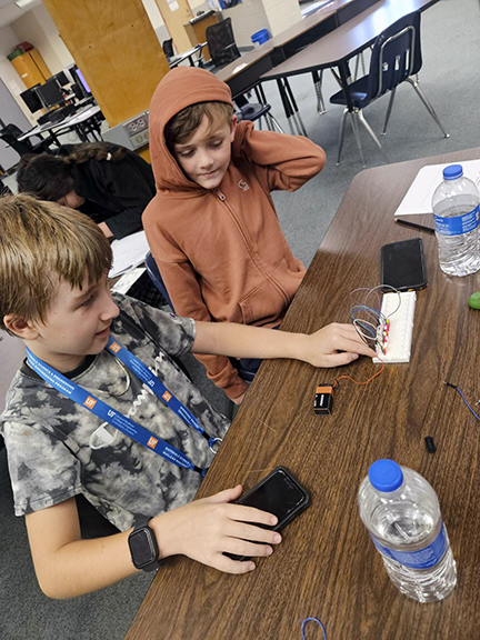 Two middle school students working on a tech project.